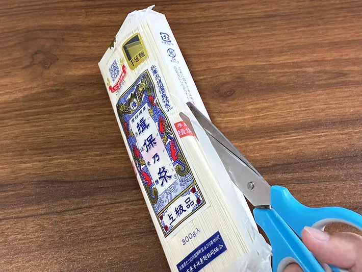 そうめん袋を下からハサミで切る場面（撮影：grapeライフハック編集部）