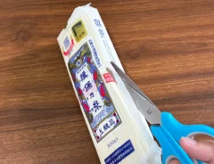 そうめん袋を下からハサミで切る場面（撮影：grapeライフハック編集部）
