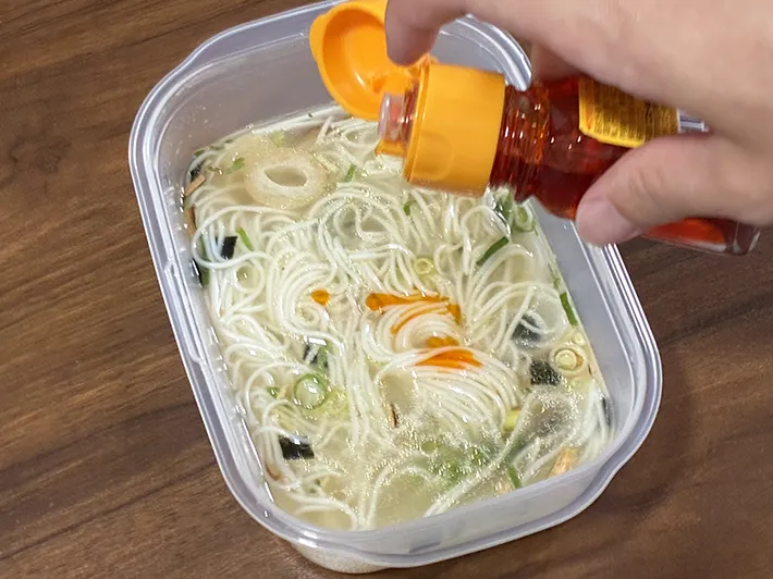 そうめんにラー油を加える場面（撮影：grapeフード編集部）