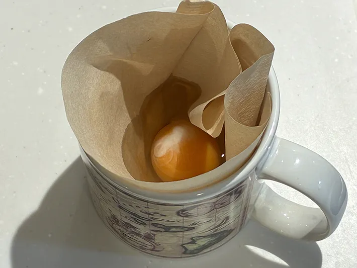 コーヒーフィルターに割り入れた卵（撮影：grapeフード編集部）