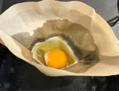 コーヒーフィルターに入れて加熱する卵（撮影：grapeフード編集部）