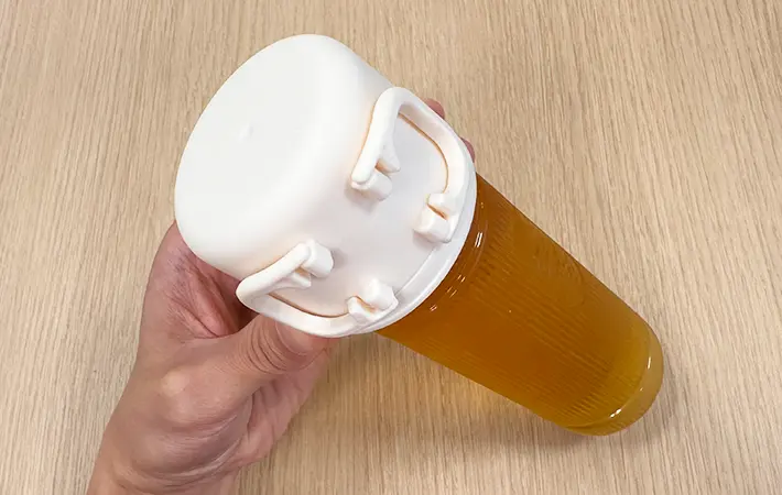 スリコのハンドル付きペットボトル用コップをペットボトル飲料につけている写真（撮影：grape編集部）
