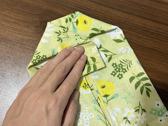 手ぬぐいの両側の角を三角に引き出す場面（撮影：grapeライフハック編集部）