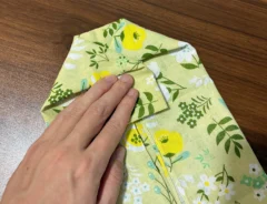 手ぬぐいの両側の角を三角に引き出す場面（撮影：grapeライフハック編集部）