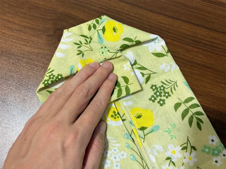 手ぬぐいの両側の角を三角に引き出す場面(撮影:grapeライフハック編集部)
