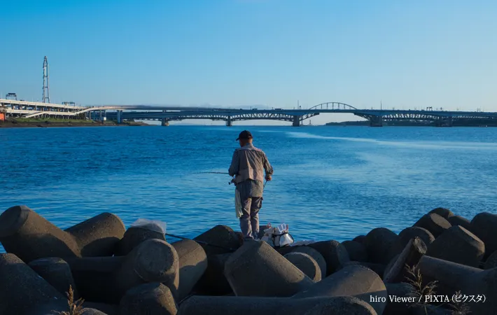 『堤防で釣りをする老人』の写真