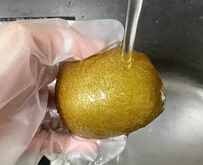 凍らせたキウイに流水をかける写真（撮影：grapeフード編集部）