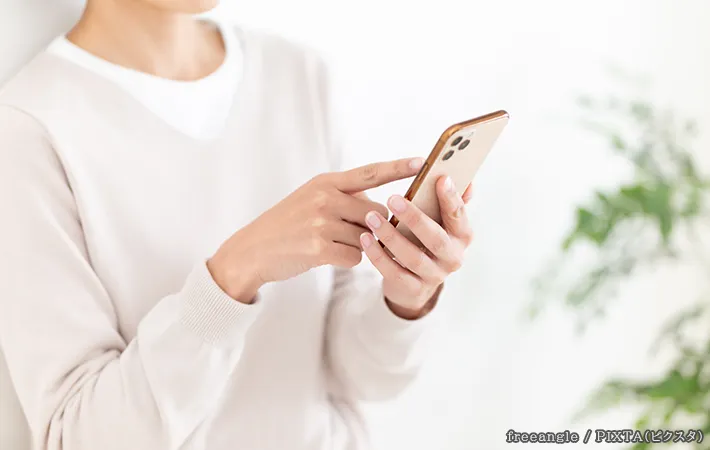 スマホを持つ人の写真