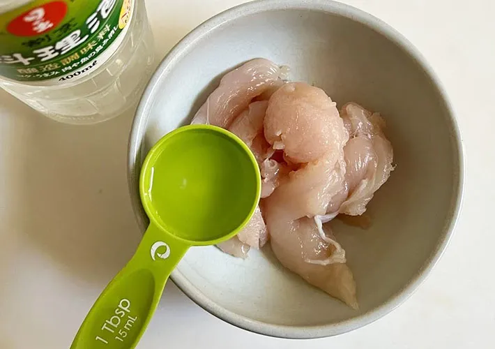 鶏ささみに料理酒をふりかけている画像（撮影:エニママ）