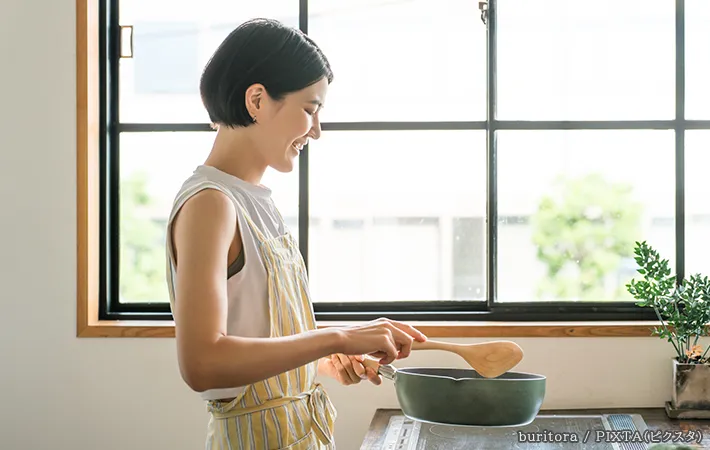 フライパンを使う女性の写真