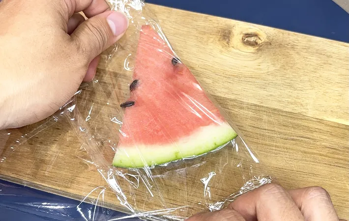 カットしたスイカを保存用ラップで包んでいる画像（撮影：キジカク）