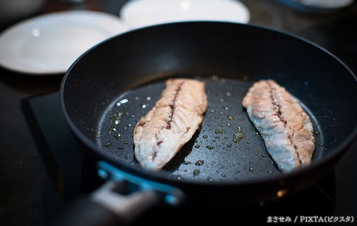 フライパンで魚を焼く写真