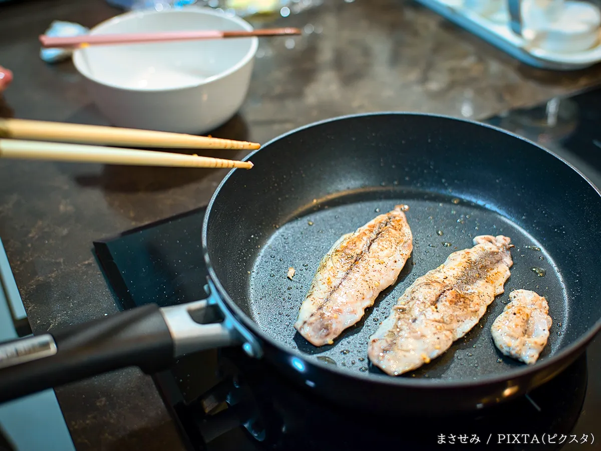フライパンで魚を焼く写真
