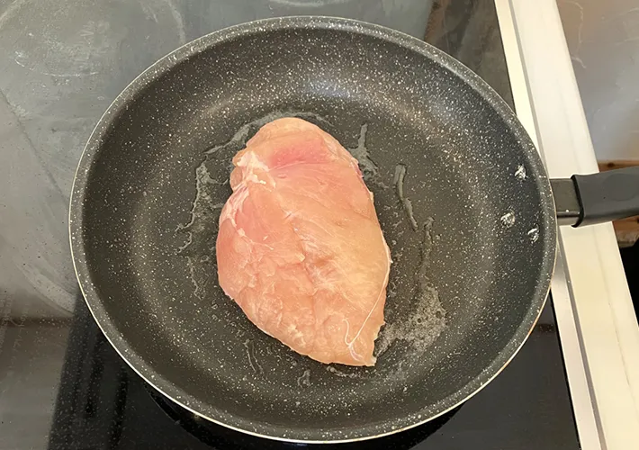 鶏肉をフライパンで焼く写真