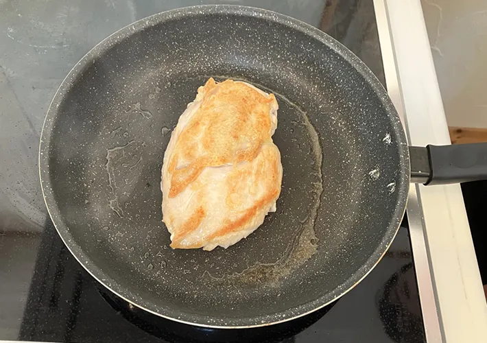 鶏肉をフライパンで焼く写真