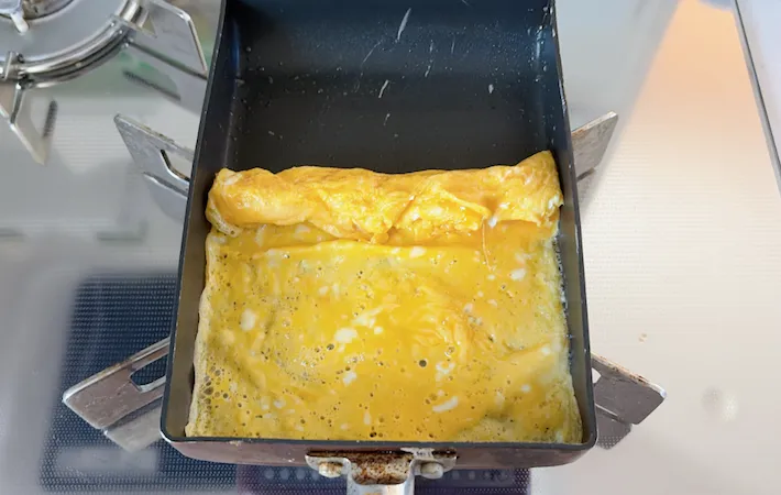玉子焼きを巻いている画像（撮影：エニママ）