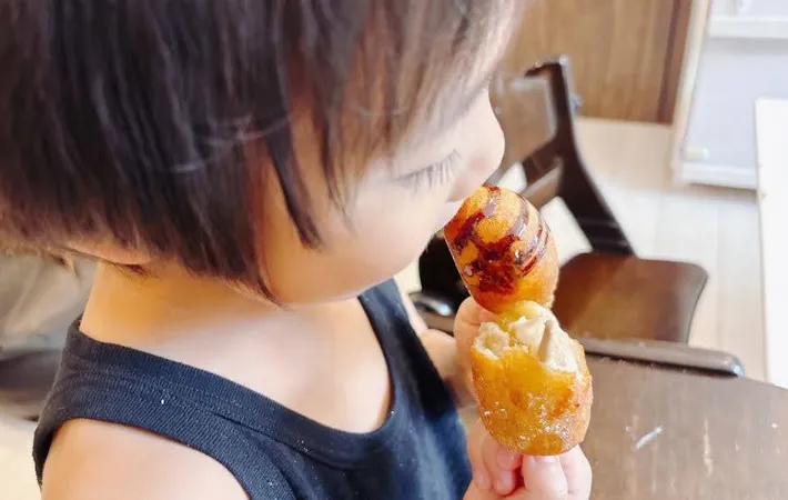 『バナナアメリカンドッグ風を食べる子供』の写真（撮影：キジカク）