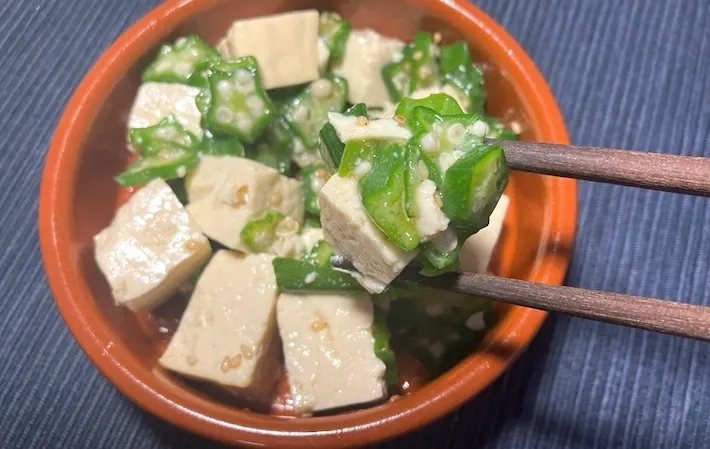 器に盛りつけた「オクラと豆腐の冷やしチャンプルー風」を箸で持ち上げる画像（撮影：キジカク）