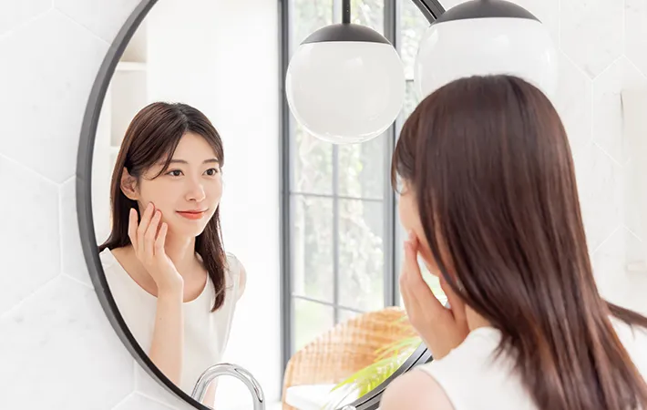 鏡をみる女性の写真
