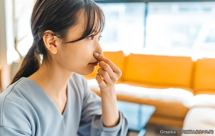 鼻をつまむ女性の写真