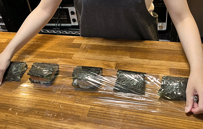 ラップを折って、おにぎりを作る写真（撮影：grapeフード編集部）