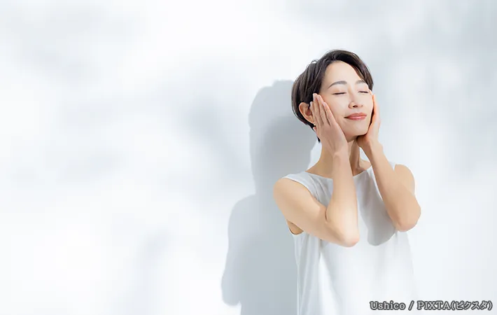 顔を触る女性の写真