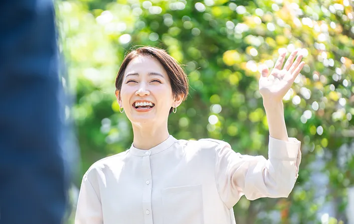 手をあげる女性の写真