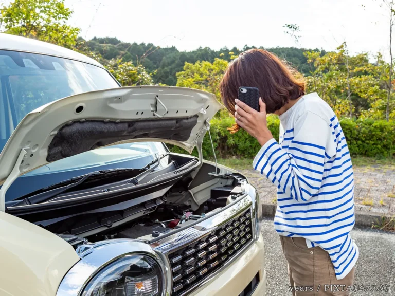 車とスマホを持つ人の写真