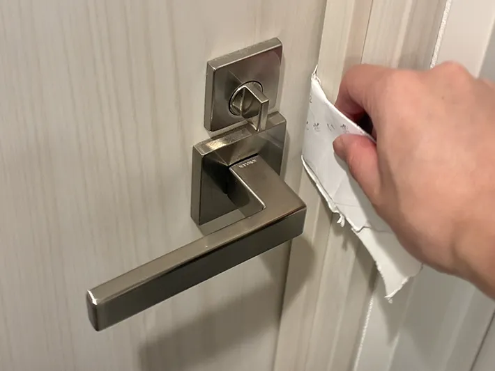 ドアの隙間に差し込む、折りたたんだトイレットペーパーの芯（撮影：grapeライフハック編集部）