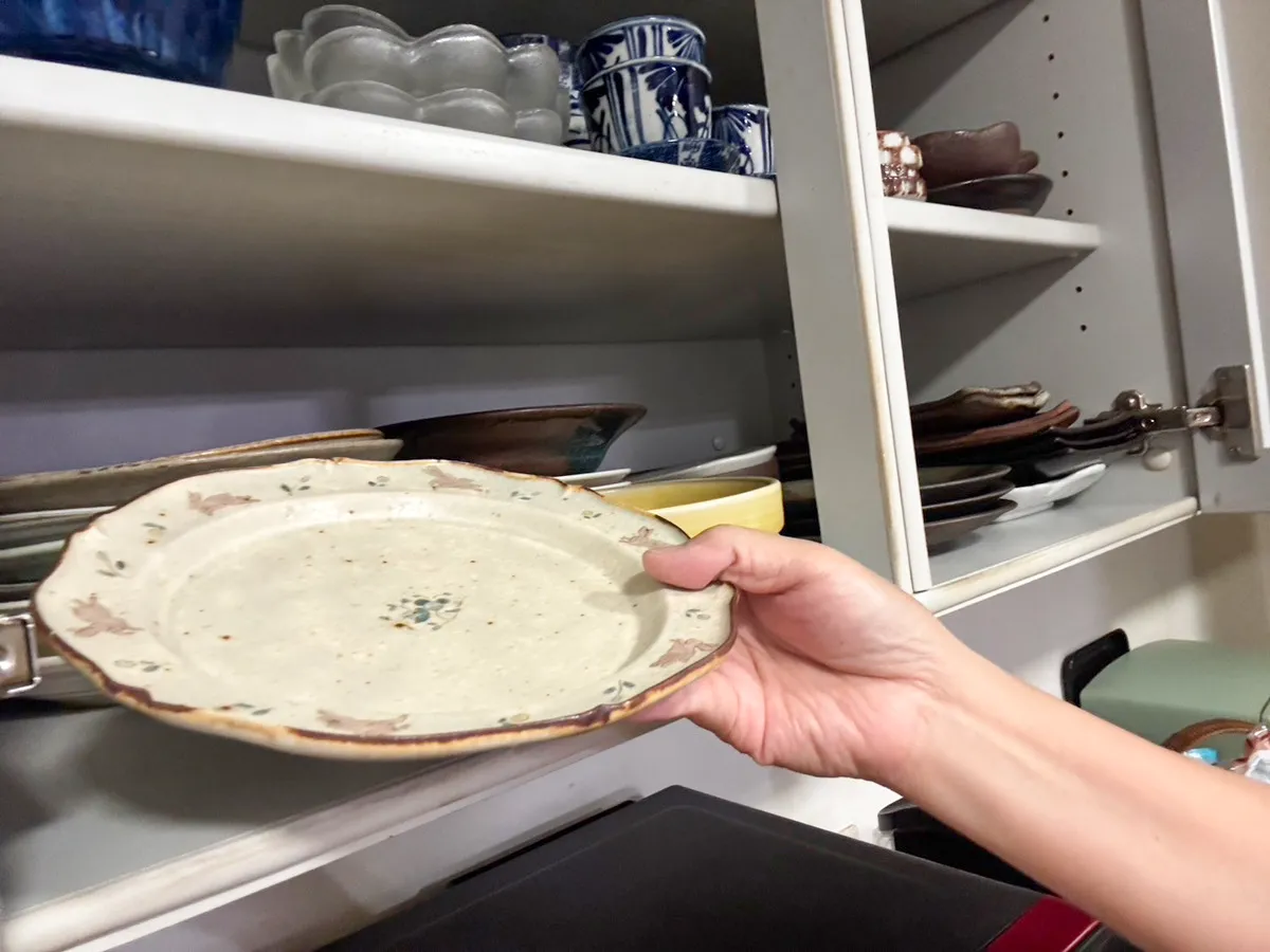 食器棚の前で手にする皿(撮影:grapeライフハック編集部)