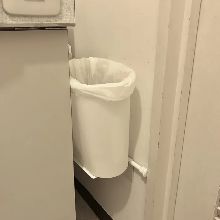 つっぱり棒とブックエンドで浮かせるゴミ箱（撮影：清水幸子さん）