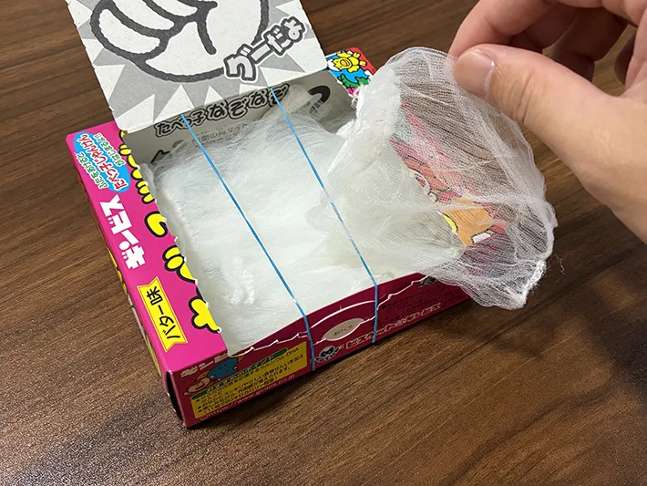 お菓子の空き箱から水切りネットを取り出す場面（撮影：grapeライフハック編集部）