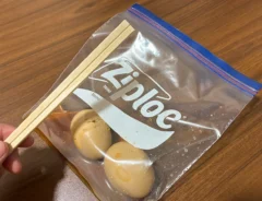 味玉を入れたジッパー袋と、手で持った割り箸（撮影：grapeライフハック編集部）