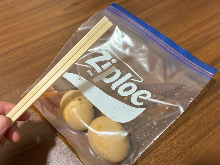 味玉を入れたジッパー袋と、手で持った割り箸(撮影:grapeライフハック編集部)