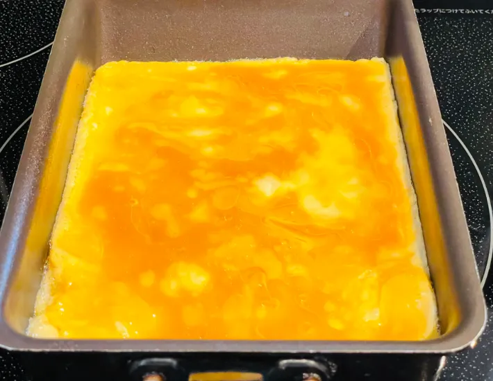 卵液を玉子焼き器に流し入れた画像（撮影：エニママ）