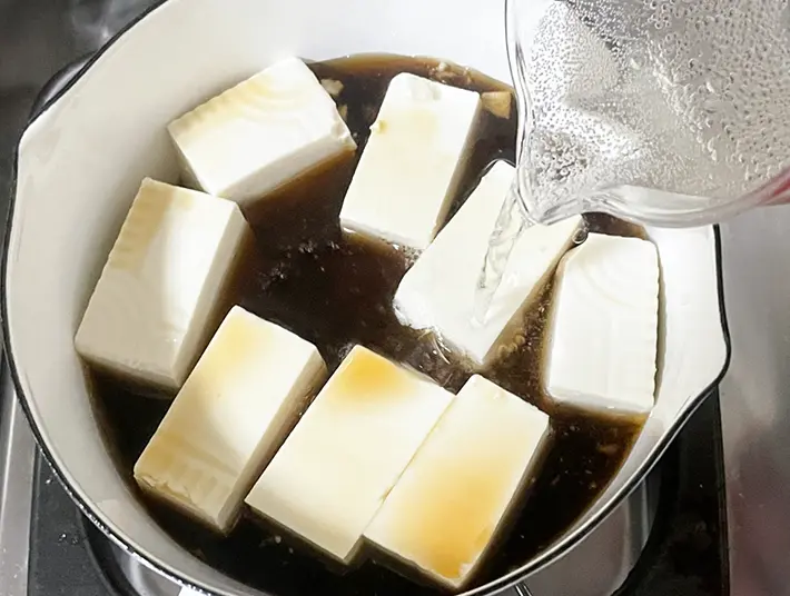 豆腐とめんつゆを入れた鍋に炭酸水を加える写真（撮影：grapeフード編集部）