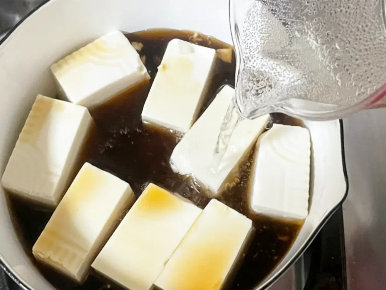 豆腐とめんつゆを入れた鍋に炭酸水を加える写真(撮影:grapeフード編集部)