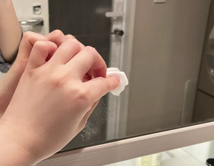 鏡をコットンで掃除する写真（撮影：grapeライフハック編集部）