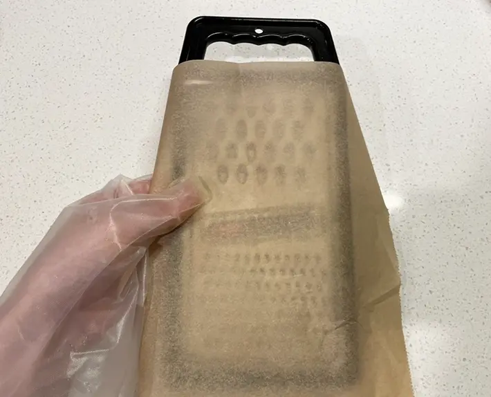 おろし器にクッキングシートを合わせる写真（撮影：grapeライフハック編集部）