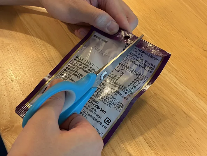 ふりかけ袋の上部に切り込みを入れる場面（撮影：grapeライフハック編集部）