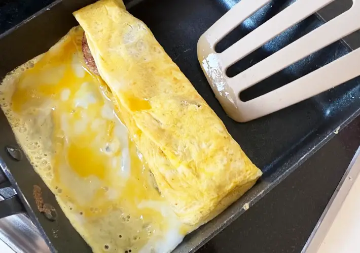 玉子焼きを巻いている画像（撮影：エニママ）