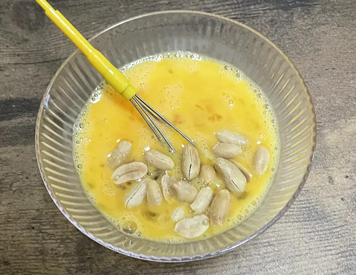 卵液にピーナッツを入れる写真（撮影：grapeフード編集部）