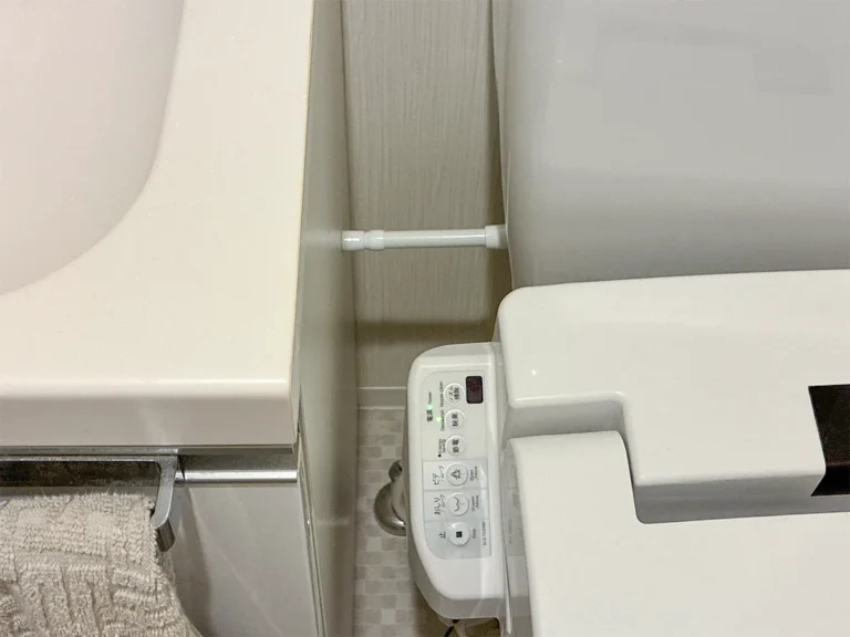 トイレのタンクと洗面台の間に設置した短いつっぱり棒(撮影:grapeライフハック編集部)