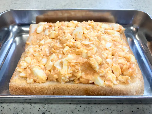 食パンに玉子フィリングをのせる場面（撮影：grapeフード編集部）