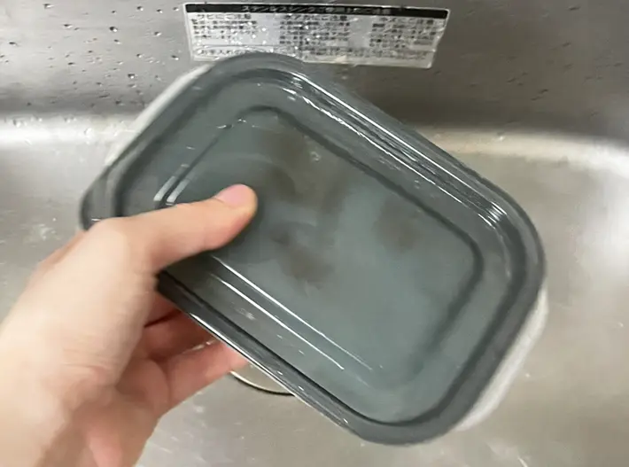 タッパーに蓋をして振る写真（撮影：grapeライフハック編集部）