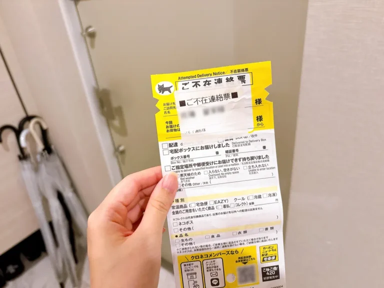 玄関で不在票を持っている写真（撮影：grapeライフハック編集部）