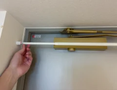 玄関ドアの上部につっぱり棒を設置する場面（撮影：grapeライフハック編集部）
