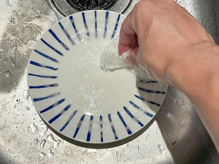 丸めたラップで皿を洗う場面（撮影：grapeライフハック編集部）