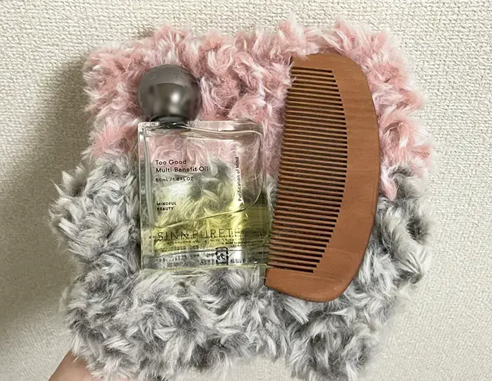 ヘアオイルとヘアブラシをマットに置いた写真（撮影：grapeライフハック編集部）