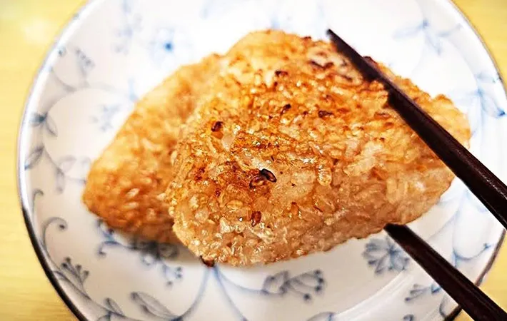 焼きおにぎりを箸で持ち上げている画像（撮影：キジカク）